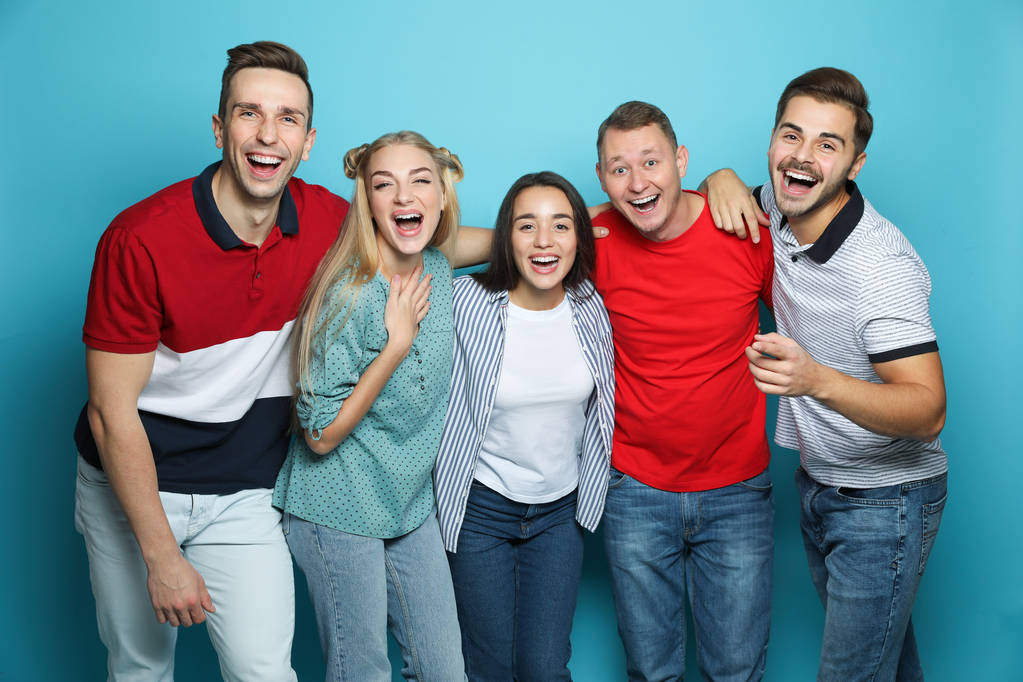 Group of friends laughing together against color background - Photo, Image