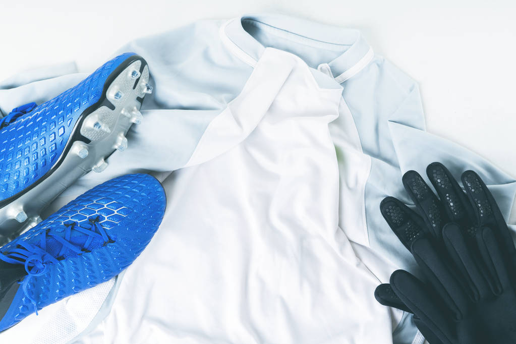 Σφήνες μπλε ποδοσφαίρου μπότες ποδοσφαίρου, παπούτσια και τα γάντια λευκό t-shirt στολή - Φωτογραφία, εικόνα
