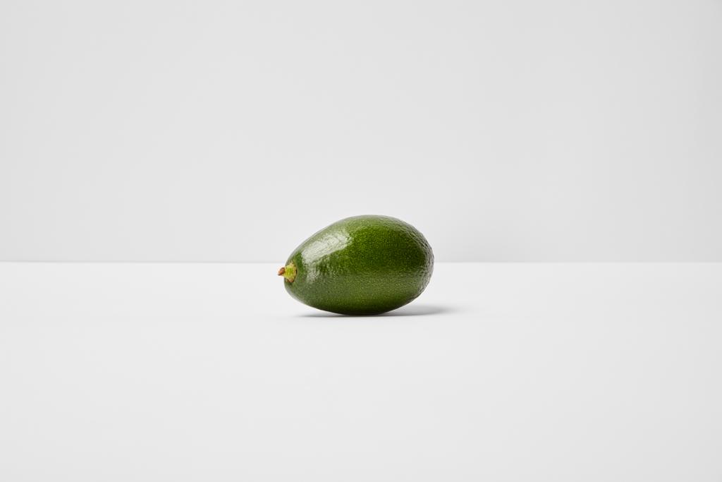 selektiver Fokus der ganzen Avocado auf grauem Hintergrund - Foto, Bild