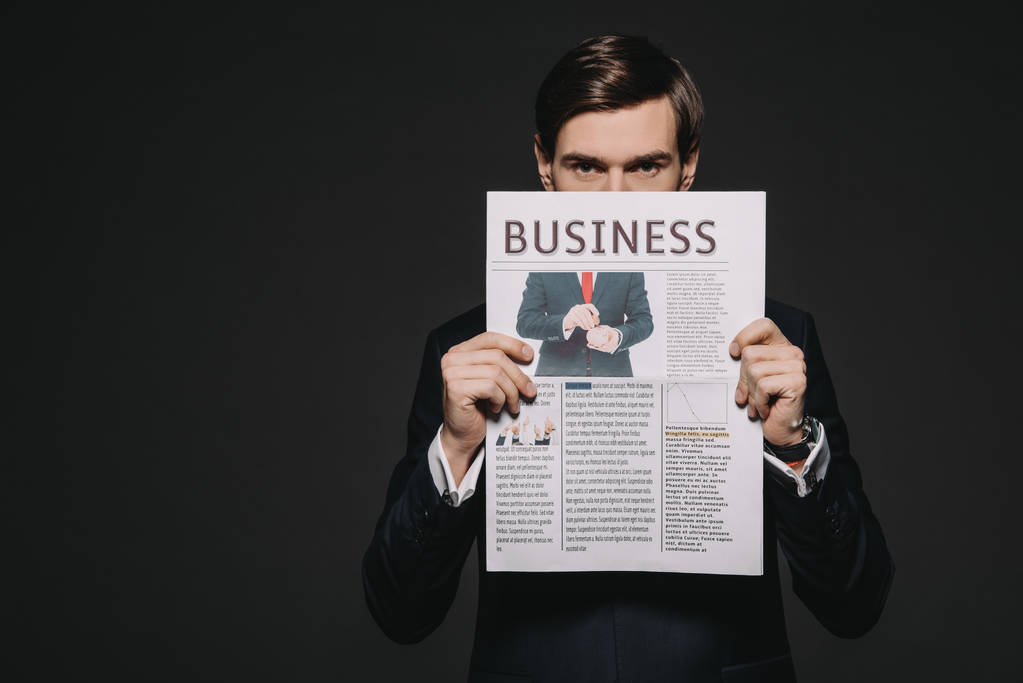 бізнесмен тримає ділову газету в руках ізольовано на чорному
 - Фото, зображення