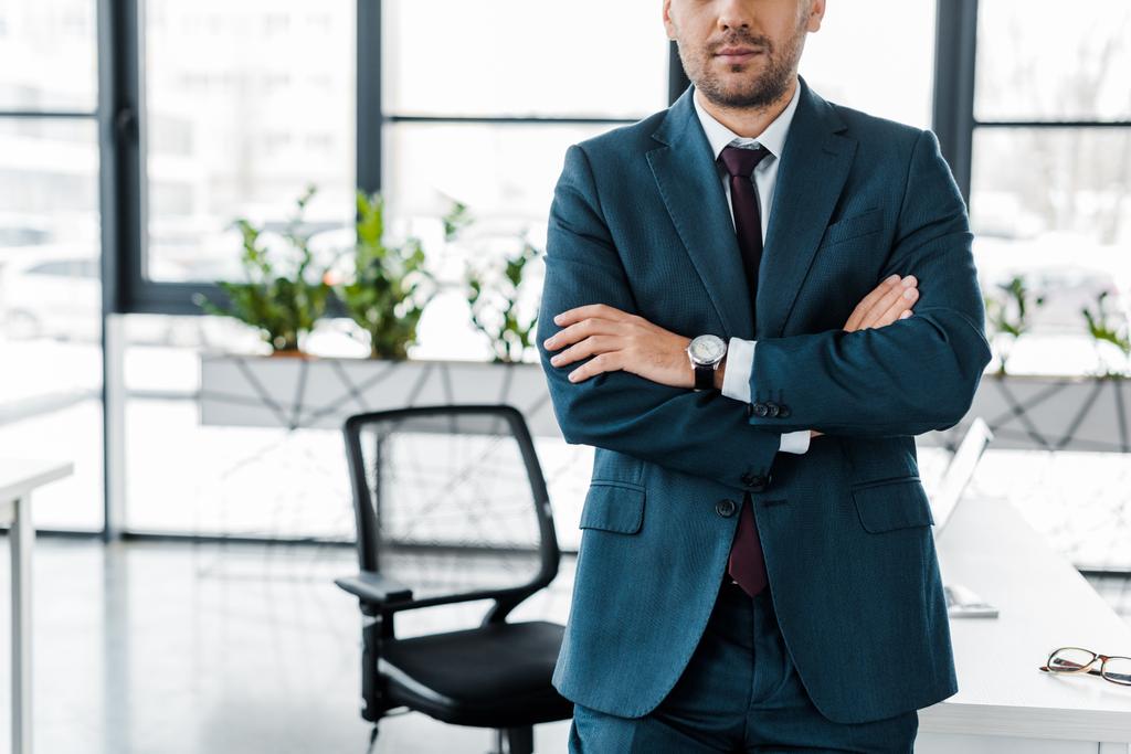 cropped view of  businessman standing with crossed arms in modern office  - Photo, Image