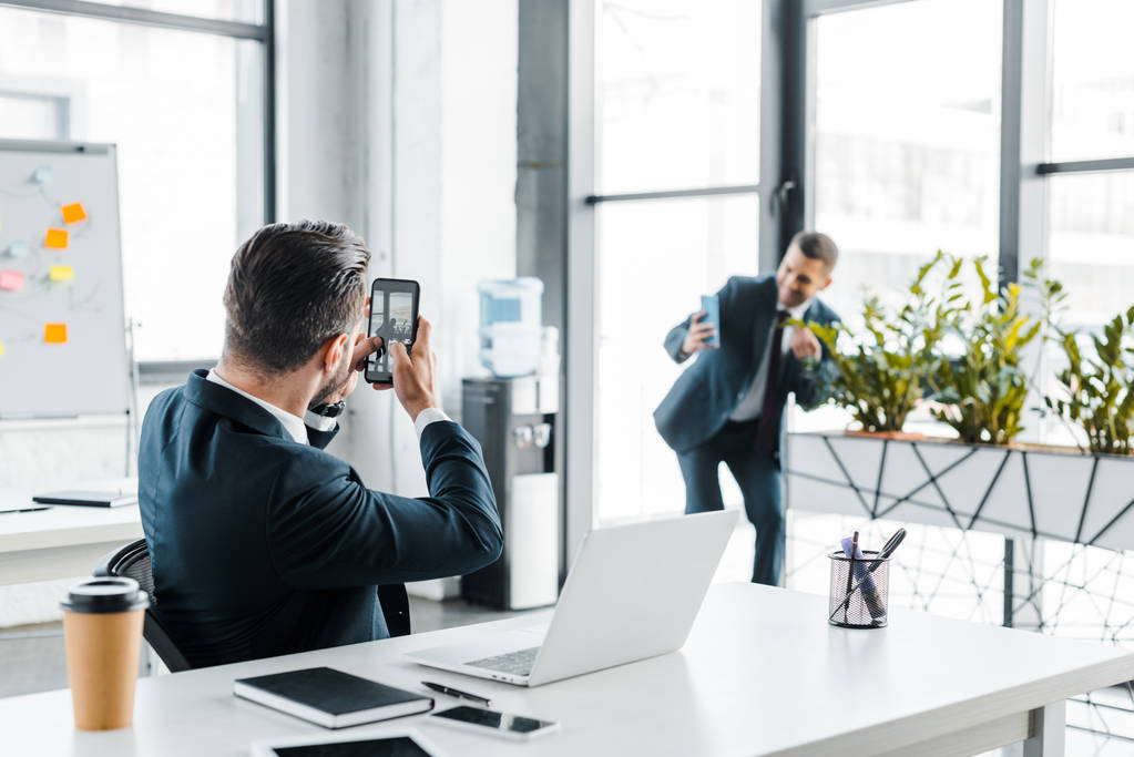 foco selectivo de hombre de negocios hablando foto de compañero de trabajo en la oficina moderna
  - Foto, imagen