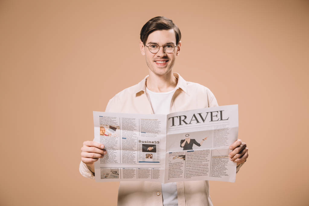 cheerful man reading travel newspaper isolated on beige  - Photo, Image