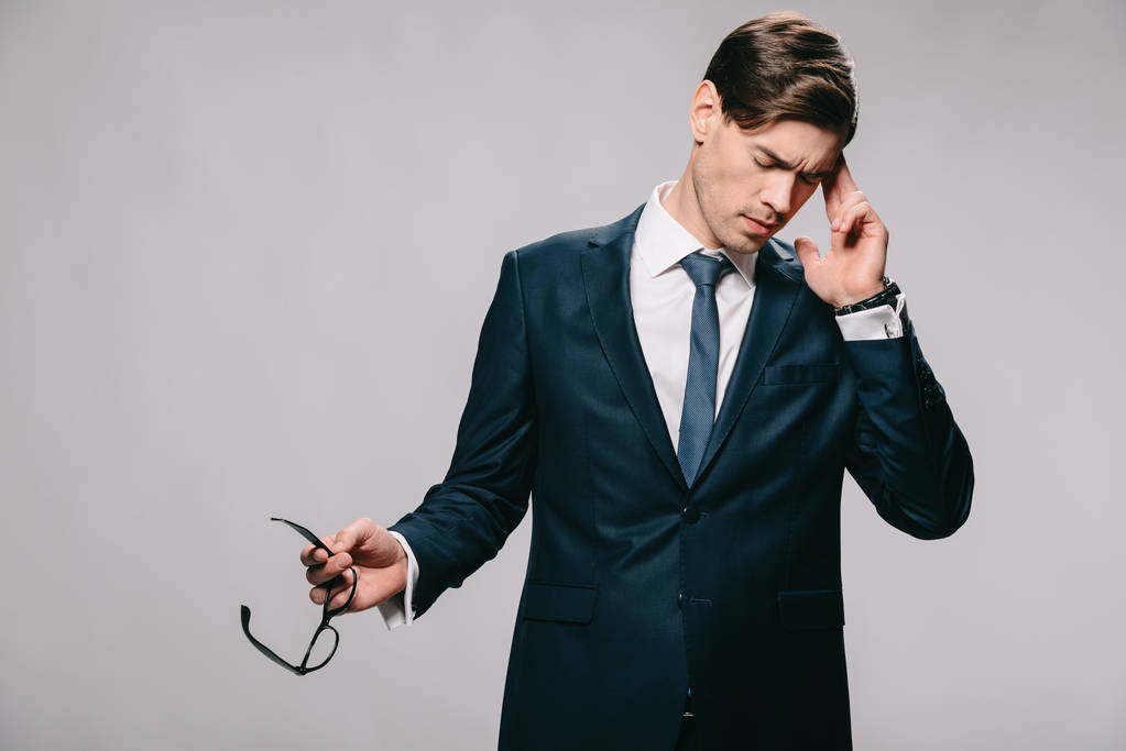 handsome businessman having headache and holding glasses isolated on grey - Photo, Image