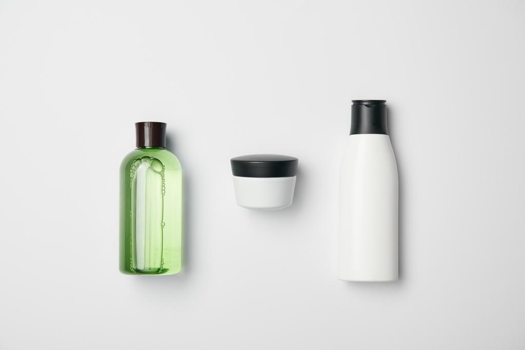 Bovenaanzicht van verschillende cosmetische flessen op witte achtergrond - Foto, afbeelding
