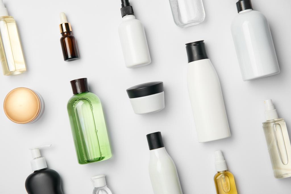 Widok z góry różnych kosmetycznych butelek i pojemników na białym tle - Zdjęcie, obraz