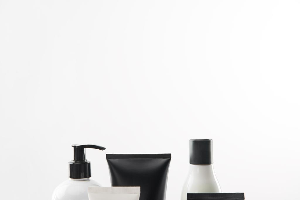 Diferentes recipientes cosméticos sobre fondo blanco con espacio de copia
 - Foto, Imagen