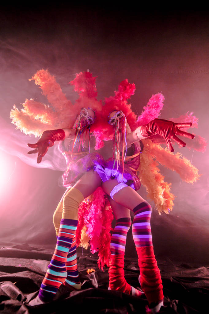 jóvenes bailarines can-can con pompones posando juntos en concepto de carnaval sobre fondo brumoso
 - Foto, Imagen