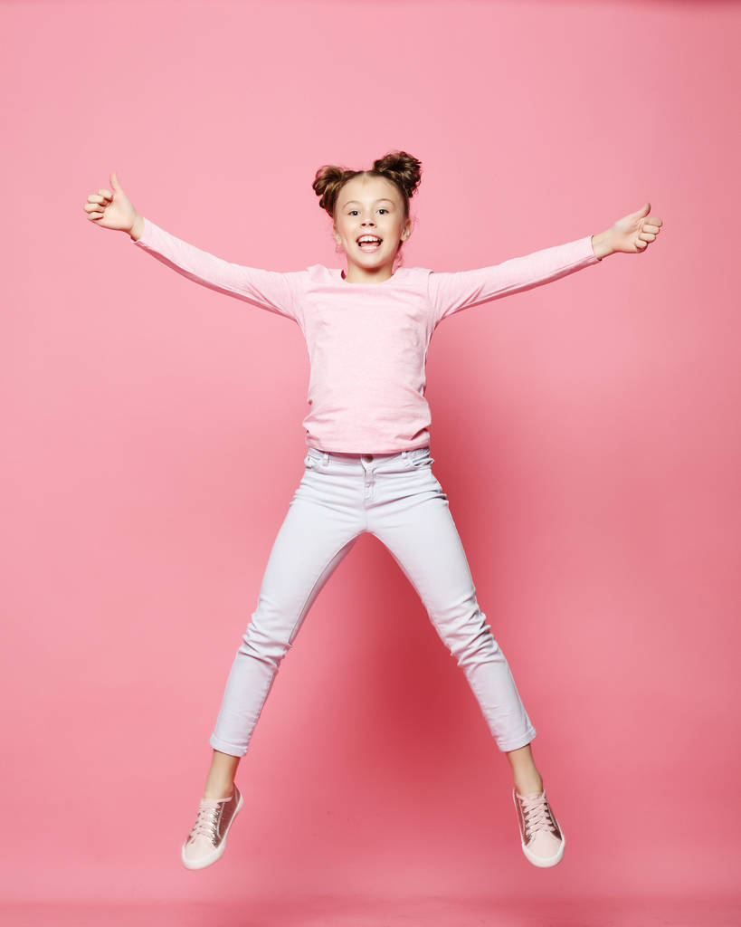  hauska lapsi tyttö pukeutunut rento hyppäämällä vaaleanpunainen tausta
  - Valokuva, kuva