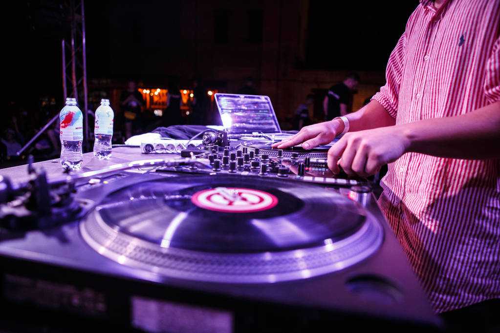 KIEV-11 JULY,2018: Hip hop dj plays music with retro Technics SL1210 turntable player on concert stage at summer festival Bazar.Entertainment event in night club.Disc jockey mixes tracks on scene - Photo, Image