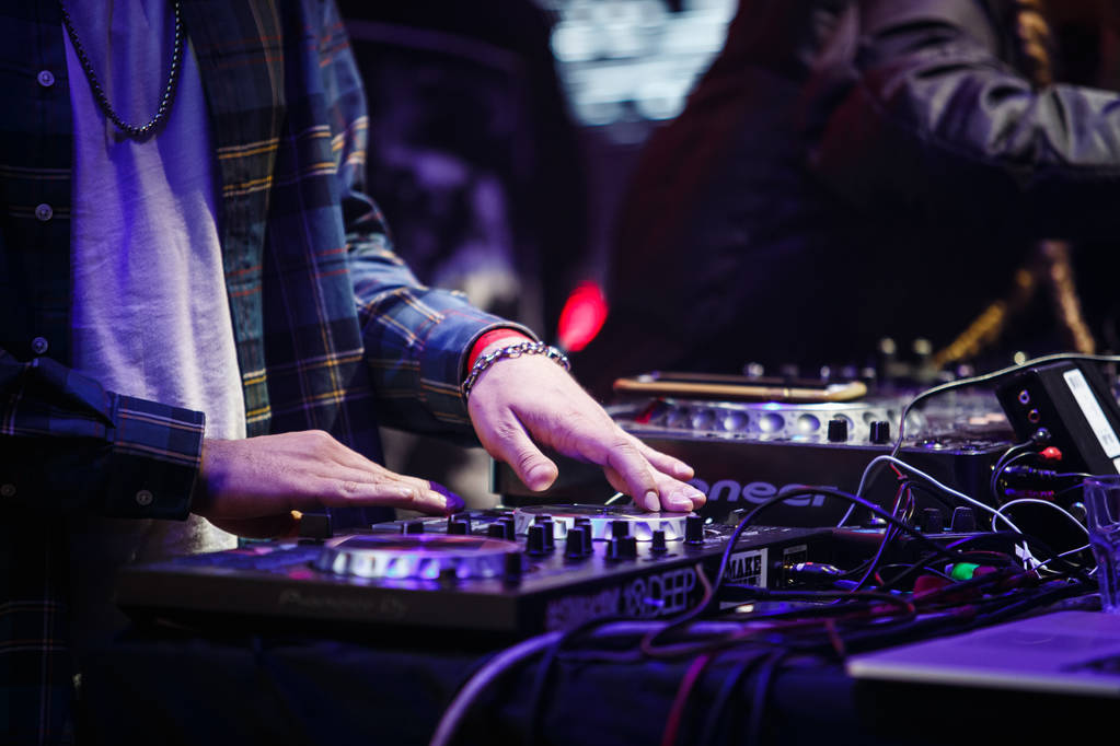 MOSCOW - 16 FEBRUARY,2017: Party dj play music on stage on concert.Hands of disc jockey scratching on digital midi turntable controller.Dj audio equipment in stage lighting.Music show event - Photo, Image
