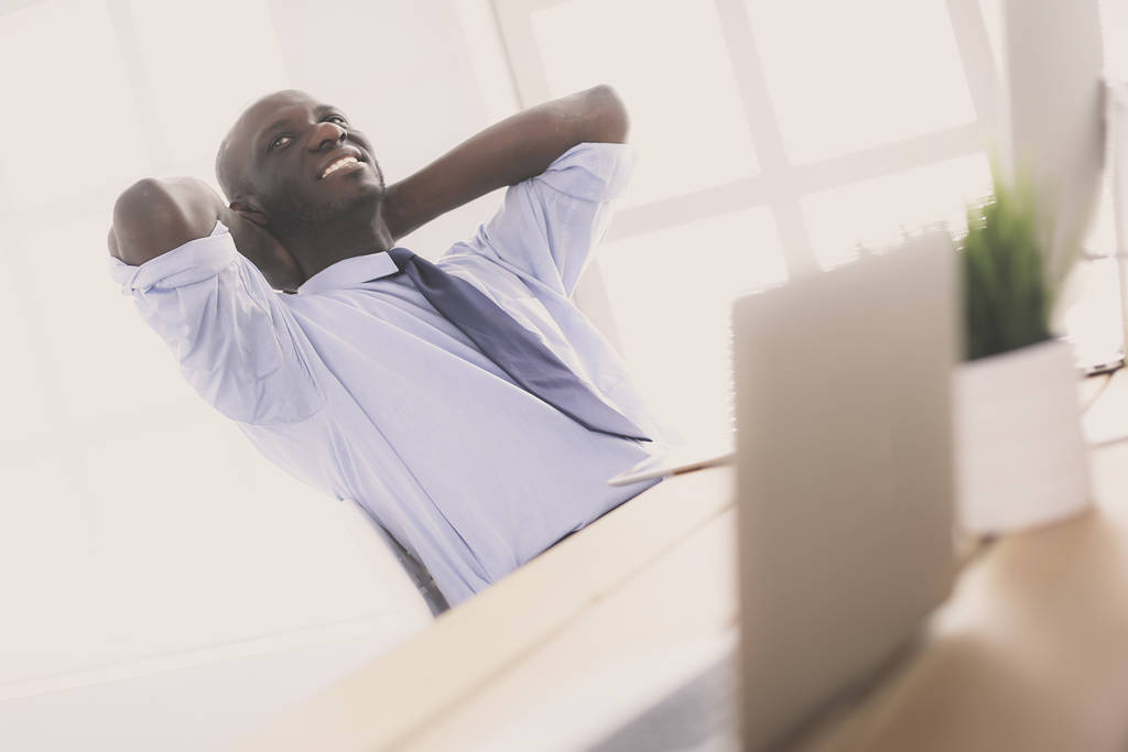 Afroamerikanischer Geschäftsmann am Headset seines Laptops - Foto, Bild