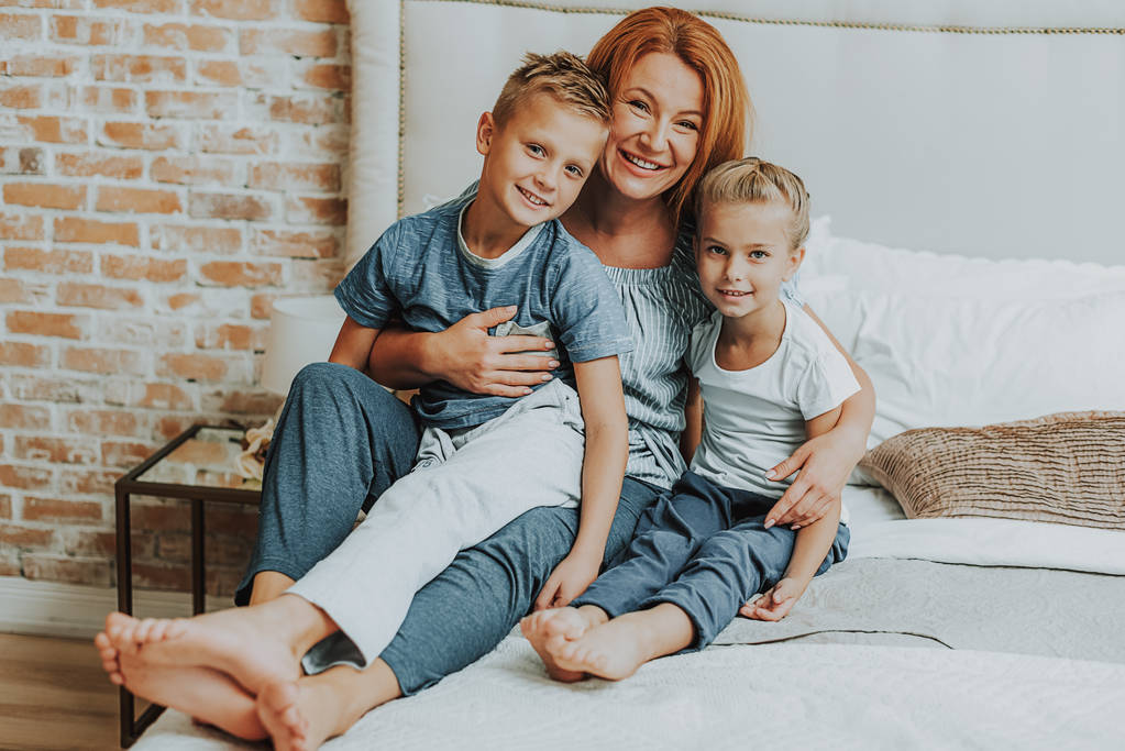 Mutlu anne ve iki çocuğu yatakta rahatlatıcı - Fotoğraf, Görsel