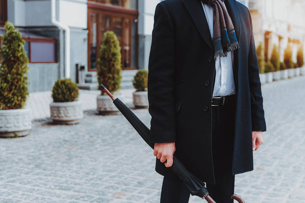 Модный человек в черном пальто интересуется в городе
 - Фото, изображение