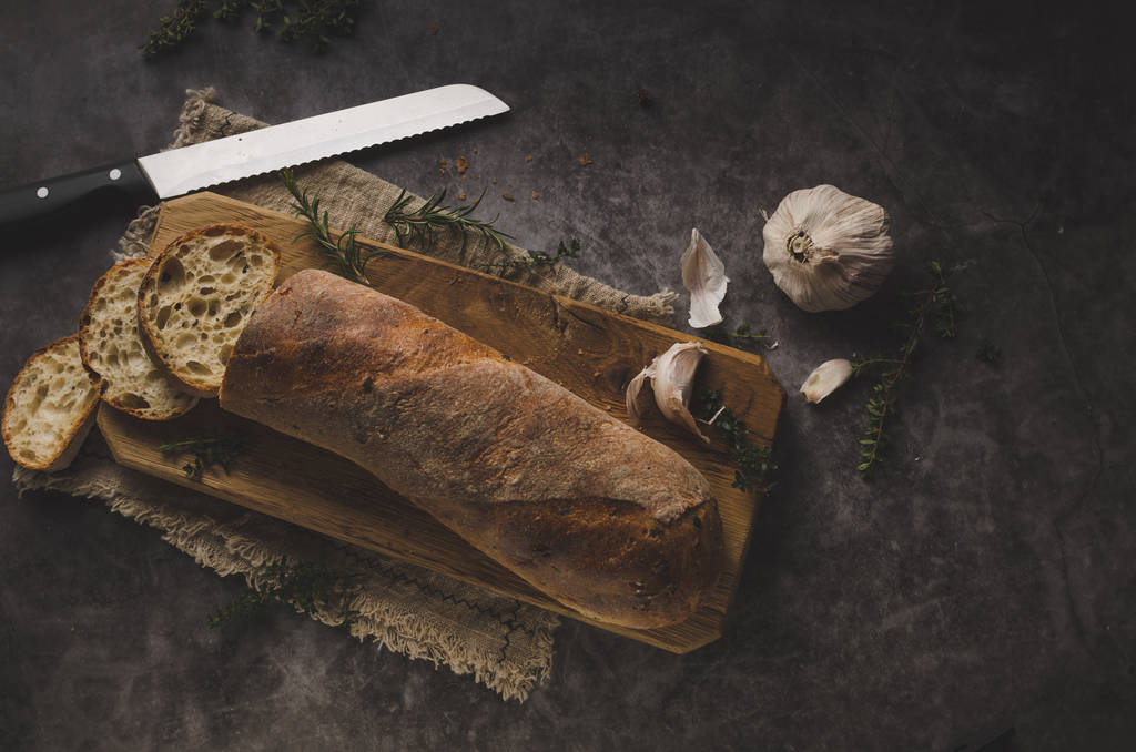 Φρέσκια ζύμη μπαγκέτα με βότανα, σκόρδο από αρτοποιείο σπίτι - Φωτογραφία, εικόνα