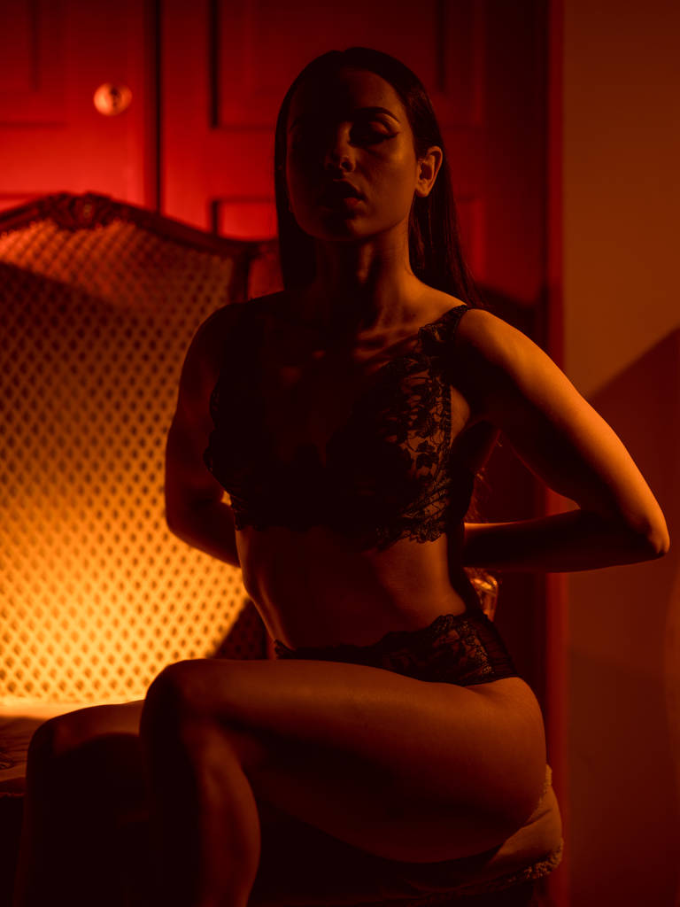 Mujer morena sensual en lencería de encaje posando en luz roja
   - Foto, imagen