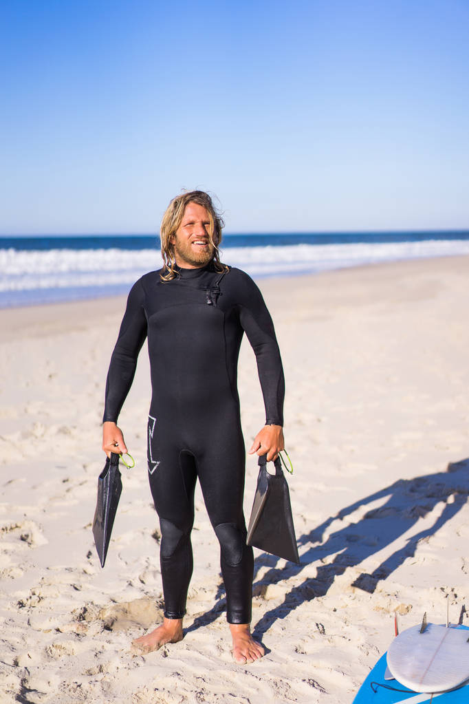 Surfer mit Schwimmflossen am Sandstrand  - Foto, Bild