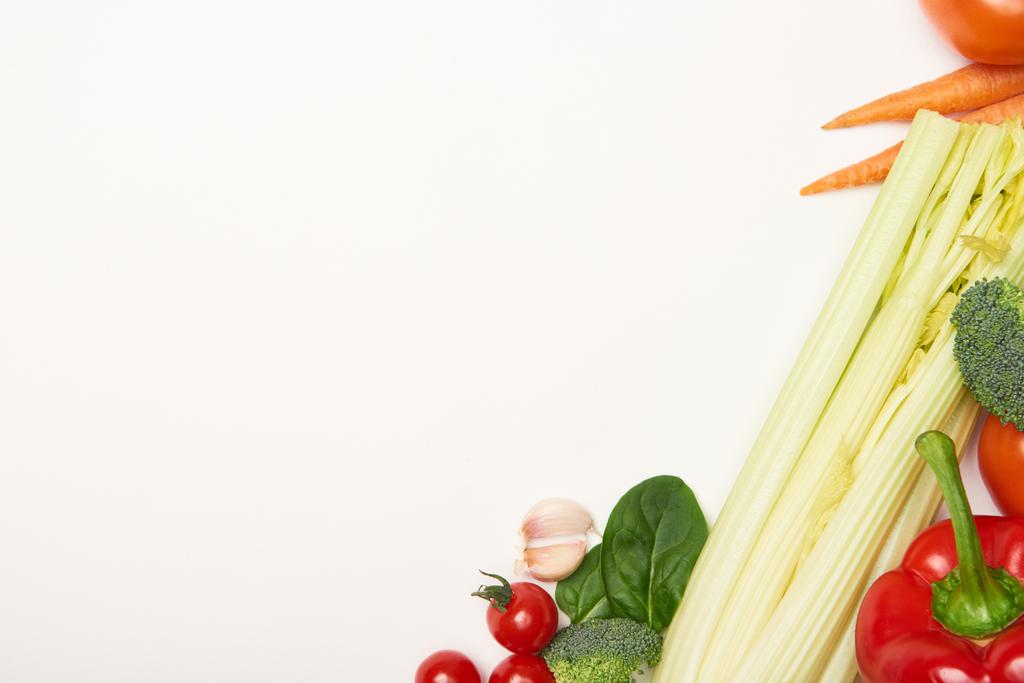 Bovenaanzicht van selderij en groenten op witte achtergrond - Foto, afbeelding