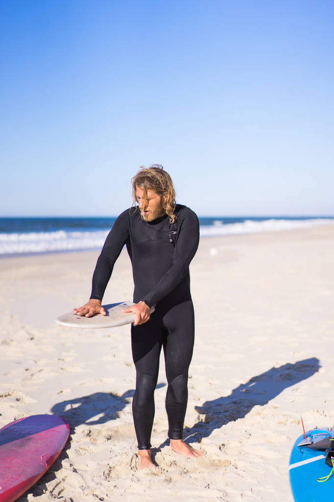 surfer with flippers and a bodyboard in a hydro suit on the ocean shore - Photo, Image