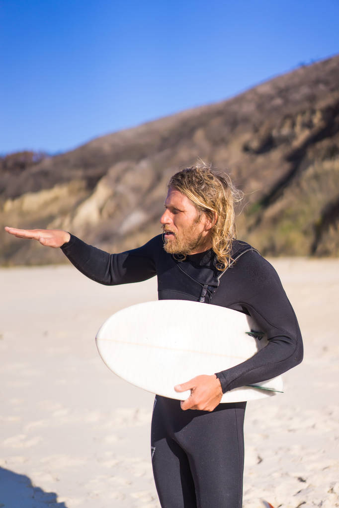 Surfer met flippers en een bodyboarden in een hidromassage pak aan de oever van de Oceaan - Foto, afbeelding