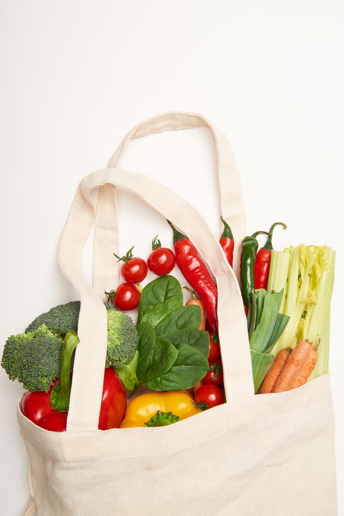 Studio shot of spinach leaves and vegetables in eco bag on white background - Photo, Image