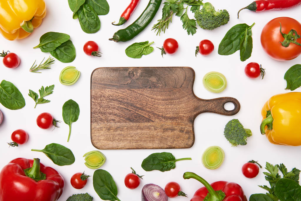 Flat lay with vegetables and wooden cutting board on white background - Photo, Image