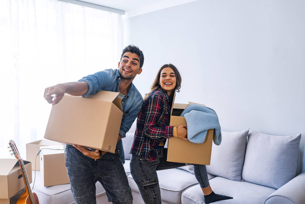 Νεαρό ζευγάρι μετακόμιση στο νέο σπίτι με κουτιά από χαρτόνι  - Φωτογραφία, εικόνα