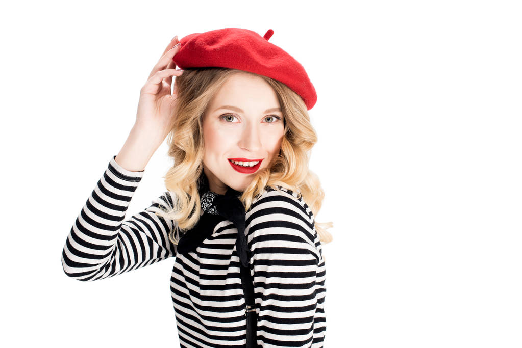 usmívající se žena držící červený baret a usmívá se, izolované na bílém - Fotografie, Obrázek