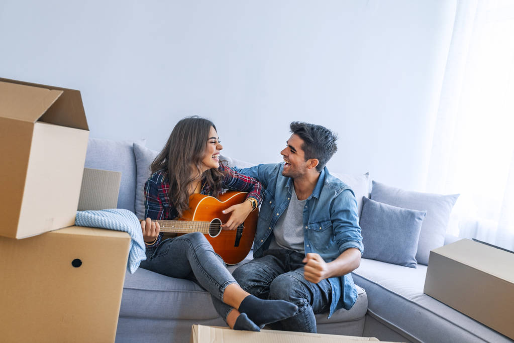 Jovem casal se divertindo com guitarra em nova casa
  - Foto, Imagem