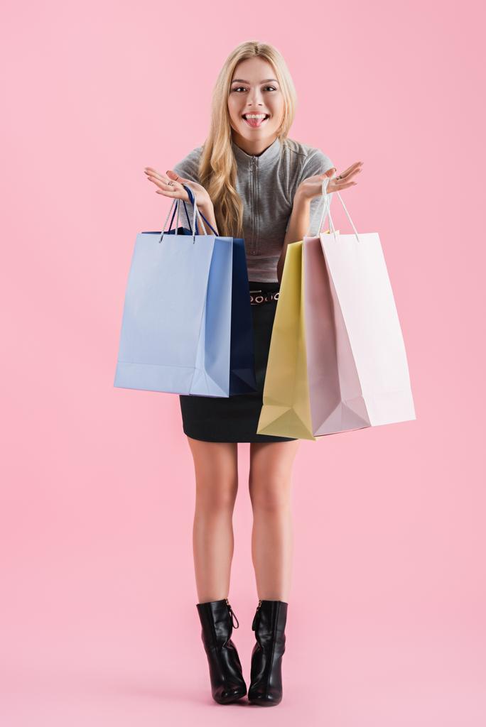schöne glückliche Frau mit Einkaufstaschen, isoliert auf rosa - Foto, Bild