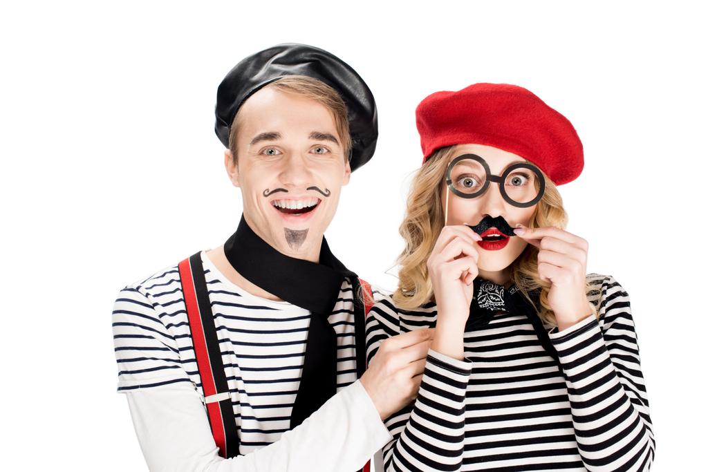 fröhlicher Mann steht neben Frau mit falschem Schnurrbart und Brille auf weißem Stock  - Foto, Bild