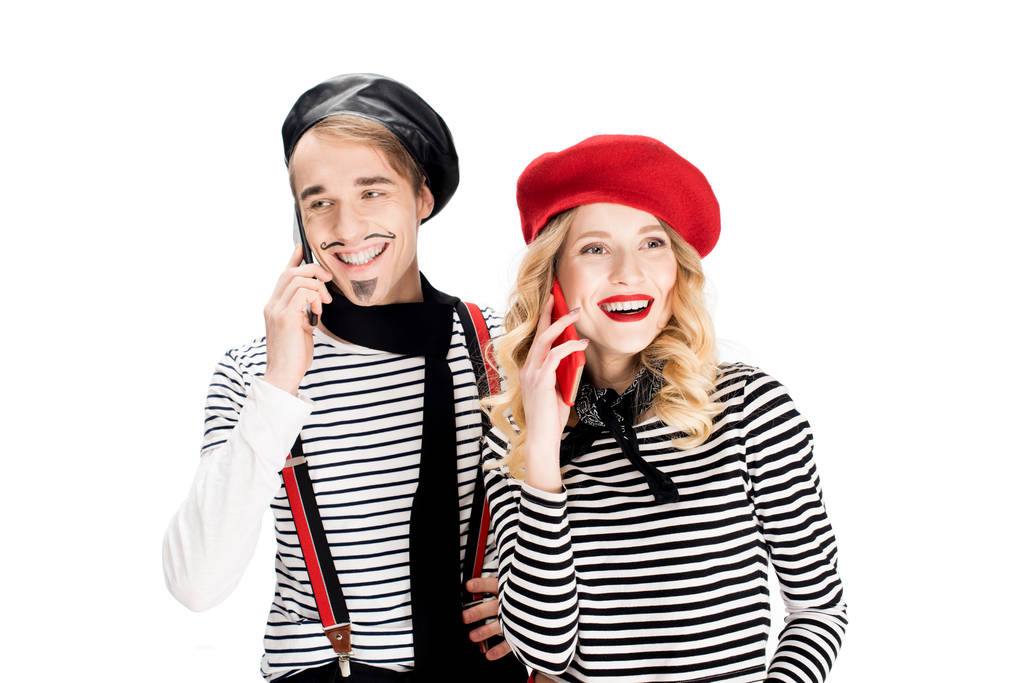 happy couple in berets talking on smartphones isolated on white  - Photo, Image