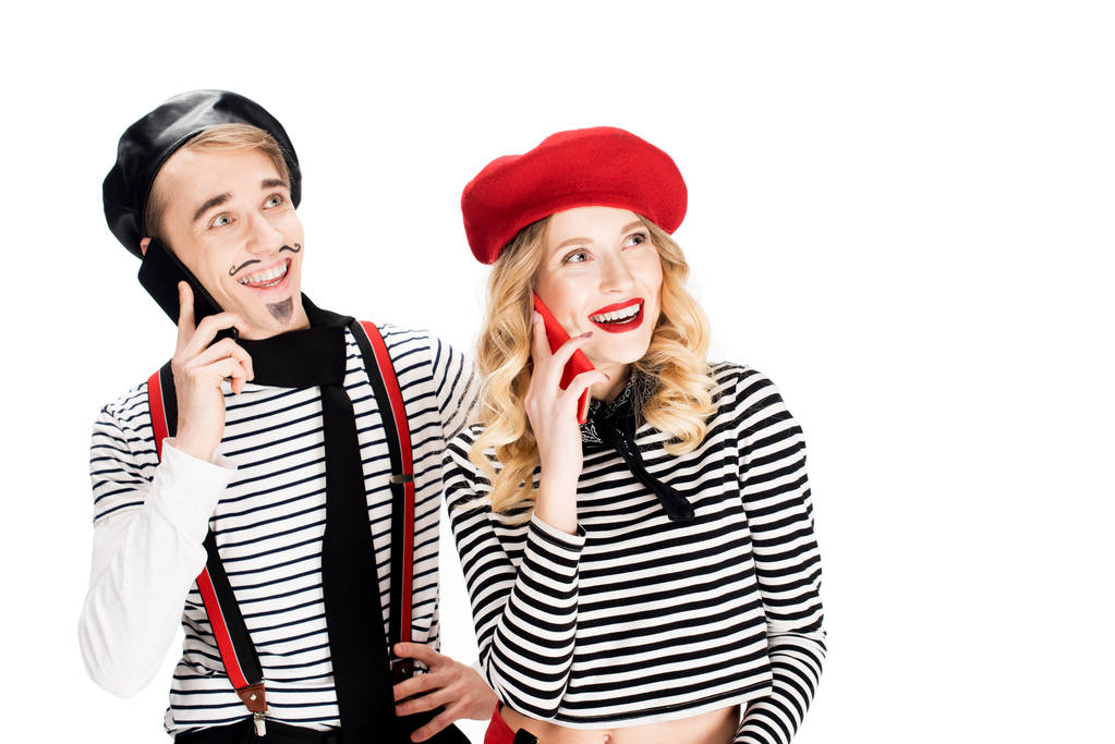 cheerful couple in berets talking on smartphones isolated on white  - Photo, Image