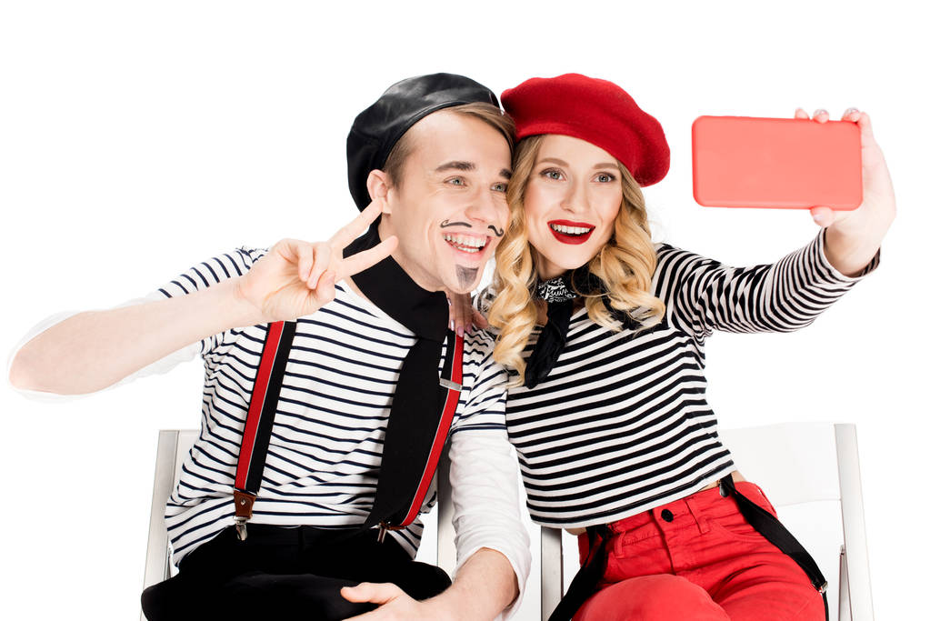 улыбающаяся французская пара делает селфи на смартфоне, изолированном на белом
  - Фото, изображение