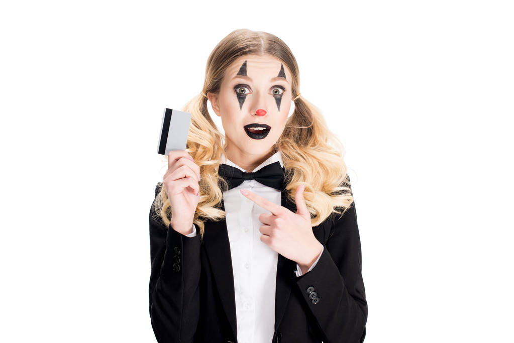 joyeux clown femelle pointant avec le doigt à la carte de crédit isolé sur blanc
  - Photo, image