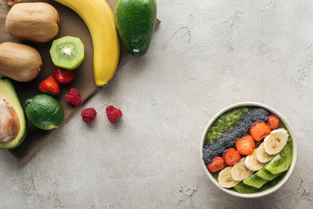 вид зверху миски з фруктами та свіжими інгредієнтами на сірому фоні
 - Фото, зображення