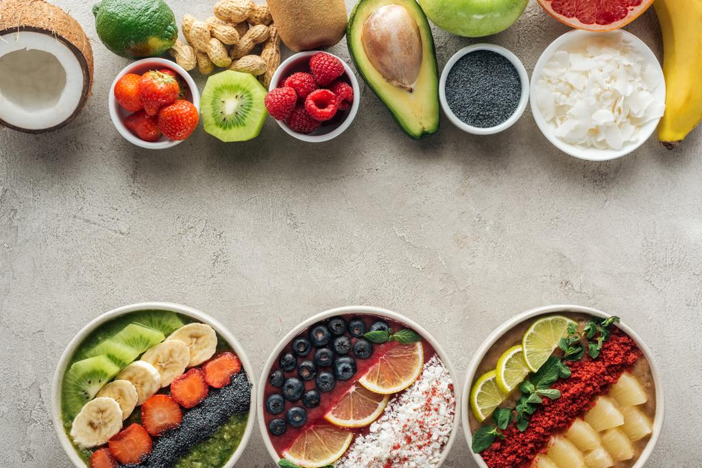 top view of smoothie bowls with ingredients on grey background - Photo, Image