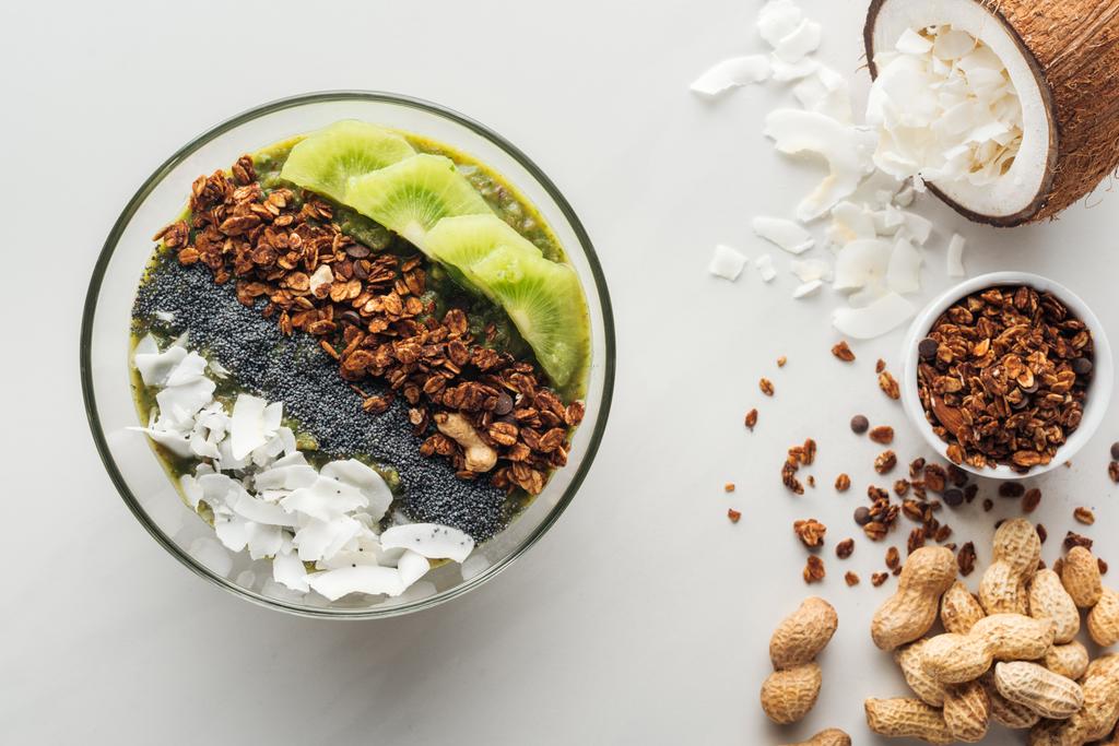 bovenaanzicht van gezonde groene smoothie kom met ingrediënten op witte achtergrond - Foto, afbeelding