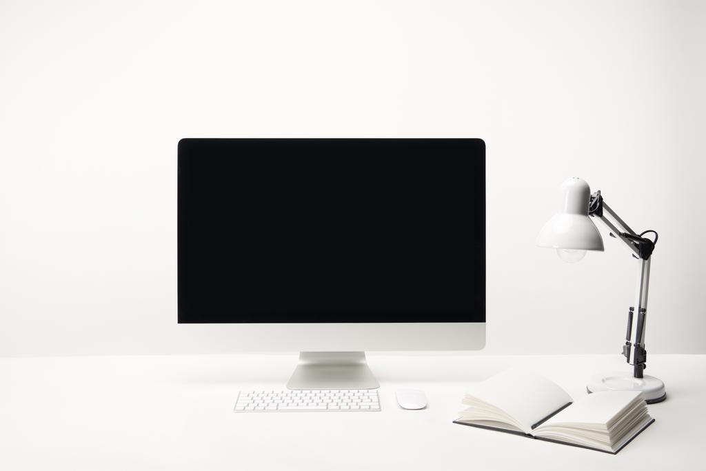 Arbeitsplatz mit Lampe, Notebook und Desktop-Computer mit Kopierraum isoliert auf weiß - Foto, Bild