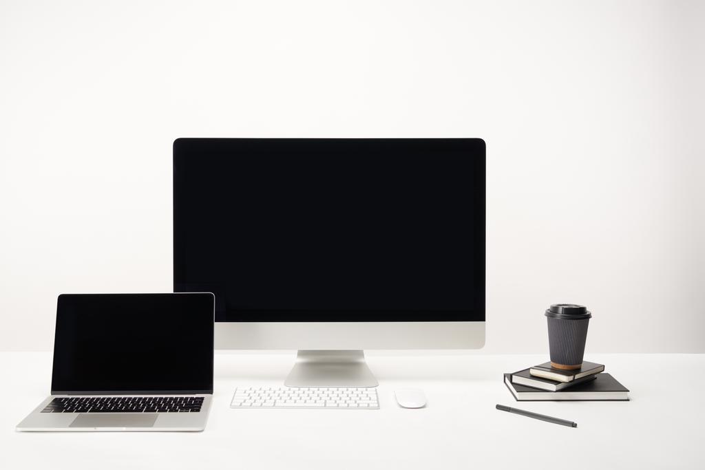 рабочее место с кофе, настольный компьютер и ноутбук с изолированным копировальным пространством на белом
 - Фото, изображение