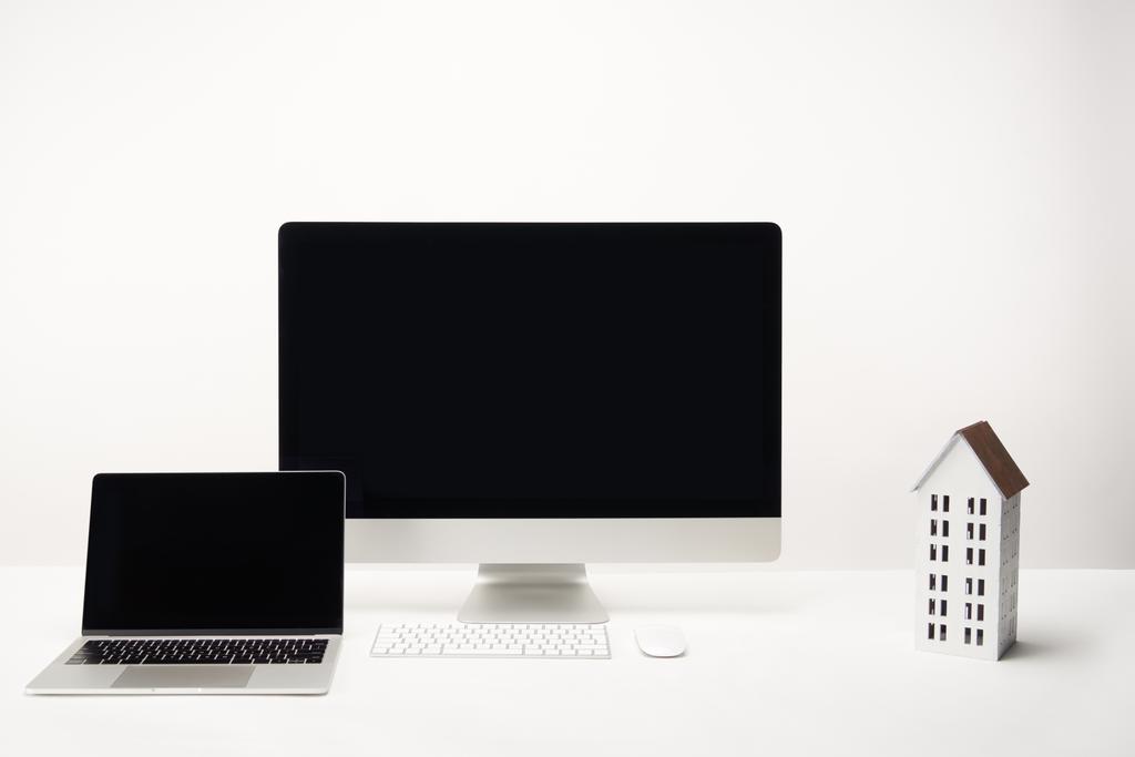munkahelyi ház modell, asztali számítógép és laptop-val másol hely elszigetelt fehér - Fotó, kép