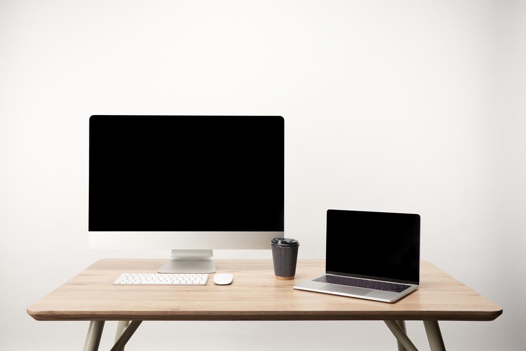 στο χώρο εργασίας με τον καφέ να πάμε, υπολογιστή γραφείου και lap-top με χώρο αντίγραφο που απομονώνονται σε λευκό - Φωτογραφία, εικόνα