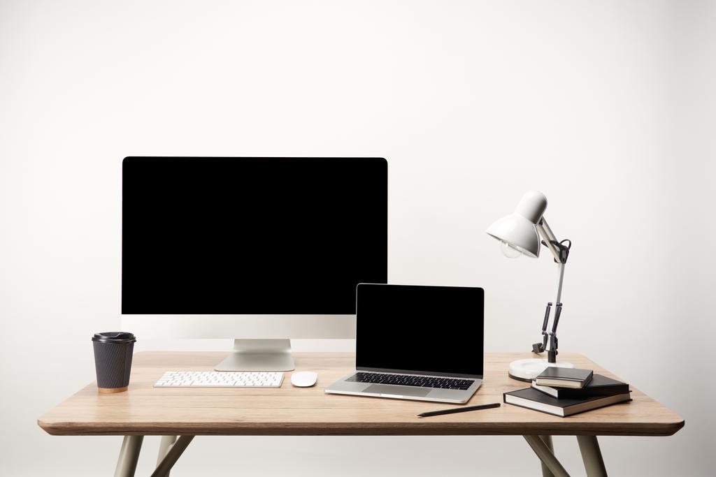 workplace with lamp, coffee to go, notebooks, desktop computer and laptop with copy space isolated on white - Photo, Image