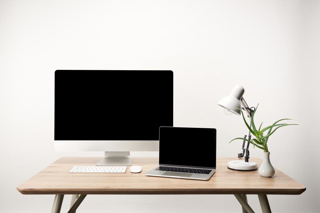 workplace with lamp, desktop computer and laptop with copy space isolated on white - Photo, Image