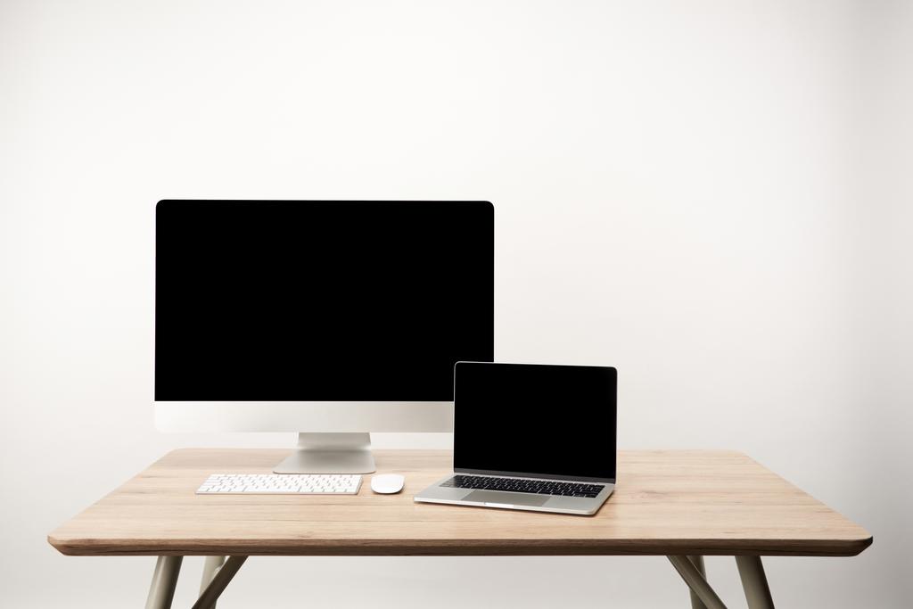 白で隔離、木製テーブルにコピー スペースでノート パソコンとデスクトップ コンピューターの職場 - 写真・画像