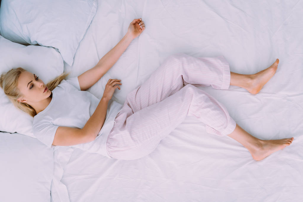 surullinen nainen pyjamassa makaa sängyssä kotona
 - Valokuva, kuva