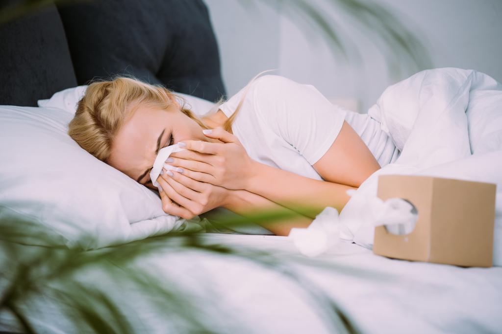 valikoiva painopiste naisen pyyhkimällä kyyneleitä ja itkua makaamassa sängyssä kotona
  - Valokuva, kuva