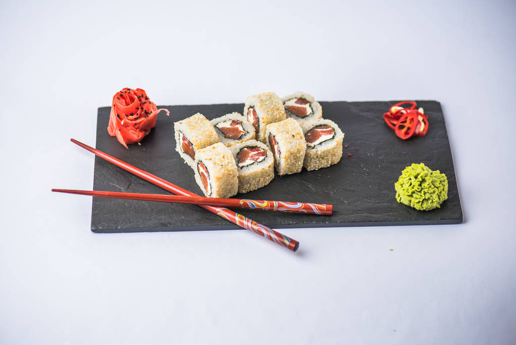 Japanese sushi roll with fish served on slate on white background - Photo, Image