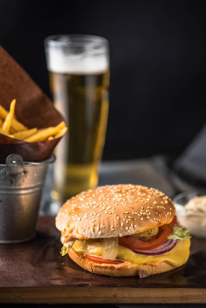 Tasty burger with french fries on wooden board - Photo, Image