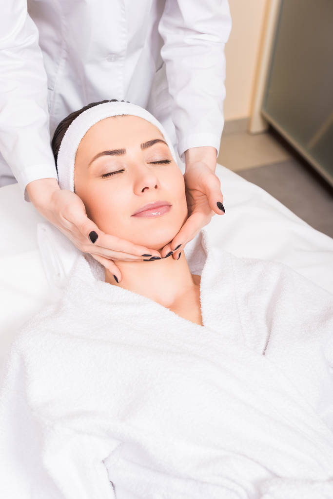cosmetologist doing manual massage on woman face at beauty salon - Photo, Image